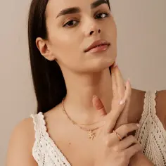 Delikatny choker na szyję z zawieszką w kształcie słońca, noszony przez młodą kobietę.