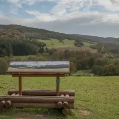 Tablica informacyjna w Magurskim Parku Narodowym prezentuje panoramę szczytów i dolin, zachęcając do odkrywania jego atrakcji.