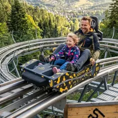 Ojciec i córka śmieją się na kolejce górskiej w Szczyrku. To świetne szczyrk atrakcje latem!