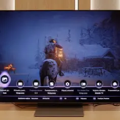 Telewizor OLED z menu gry, pokazujący zimową scenę. Porównanie qd oled vs oled w grach.