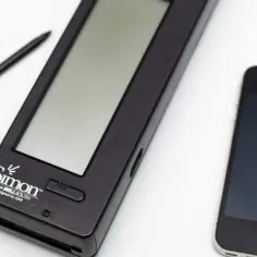 Pierwszy smartfon dotykowy Simon obok nowoczesnego iPhone'a. Stylus leży obok.
