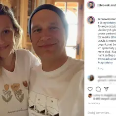 Aleksandra Żebrowska i Michał Żebrowski uśmiechają się do zdjęcia. Ola ma na sobie białą koszulkę z motywem kwiatowym.
