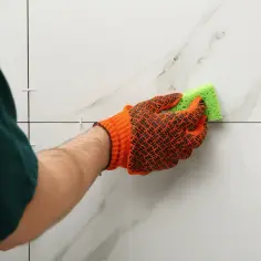Rękawica z gąbką czyści płytki. Dowiedz się, jak usunąć klej Mamut z płytek, by uzyskać idealnie czystą powierzchnię.