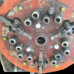 Mechanizm dociskowy sprzęgła T25. Widać śruby mocujące (A) i dociskowe (B).
