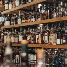Półki pełne butelek whisky. Zastanawiasz się, ile kalorii ma whisky z colą? To zależy od ilości i rodzaju alkoholu.