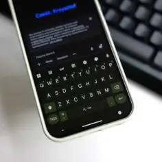 Klawiatura Gboard na telefonie wyświetla zapytanie do Gemini. Widoczny jest też fragment klawiatury fizycznej.