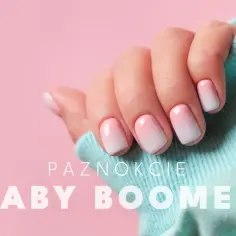 Dłoń z paznokciami hybrydowymi w stylu baby boomer, delikatny gradient różu i bieli.