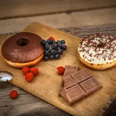 Słodka uczta: pączki, czekolada i owoce leśne na desce. Idealna pizza na słodko!