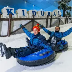 Para zjeżdża na pontonie po śniegu na stok narciarski w Dubaju.