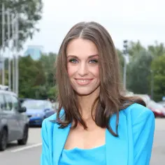Julia Kamińska w błękitnym żakiecie, gotowa na premierę kolejnych filmów. Uśmiechnięta, z niebieskimi oczami, prezentuje się promiennie.