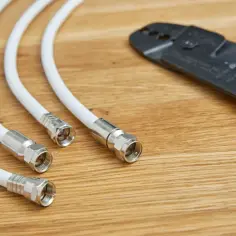 Narzędzia do montażu kabli antenowych: kilka białych przewodów z końcówkami F i obcinak do kabli. Dowiedz się, jak połączyć przewód antenowy.