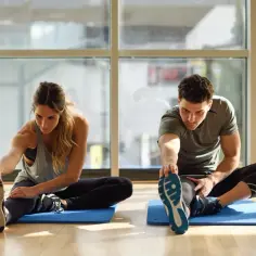 Para ćwiczy rozciąganie, pokazując, co daje stretching: lepszą gibkość i przygotowanie mięśni do wysiłku.