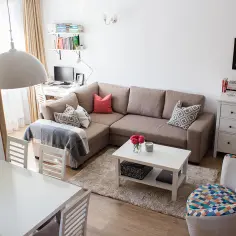 Przytulny salon z narożnikiem, stolikiem kawowym i jadalnią. Inspiracja, jak oszczędzać na mieszkanie, tworząc funkcjonalną przestrzeń.