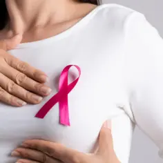 Kobieta z różową wstążką na piersi, symbolem walki z rakiem piersi. Leczenie tamoxifenem daje nadzieję.