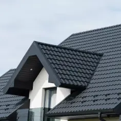 Nowoczesny dach dwuspadowy z ciemnej blachodachówki. Zastanawiasz się, ile kosztuje dach dwuspadowy?