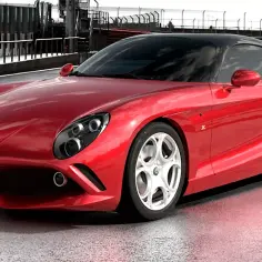 Czerwone Alfa Romeo 8C na torze wyścigowym, z czarnym dachem i błyszczącym lakierem.