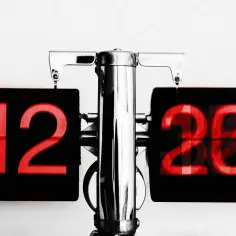Stary zegar z czerwoną tarczą pokazuje 12:20. Jak legalnie udowodnić kradzież czasu pracy przez pracownika?