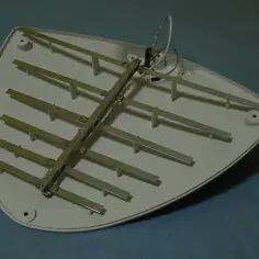 Antena telewizyjna z metalowymi elementami na białej obudowie. Dowiedz się, jak włączyć zasilanie anteny w telewizorze TCL.
