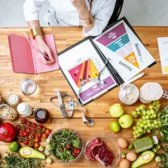 Intendentka planuje zdrową dietę, analizując piramidę żywienia i proporcje makroskładników. Na stole świeże produkty, suplementy i miarka.