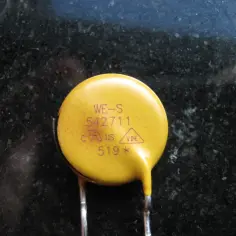 Żółty warystor z oznaczeniami WE-S 542711, c-us, VDE, 519*.