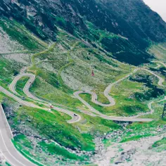 Malownicza trasa transalpina wijąca się serpentynami po zielonych zboczach gór.