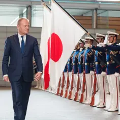 Uroczyste powitanie w Japonii. Polska delegacja z flagami Japonii i honorową asystą wojskową.