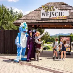 Smok i postacie w strojach witają gości przy wejściu do Parku Miniatur. Sprawdź inwałd park cennik i zaplanuj wizytę!