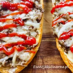 Pyszne zapiekanki z pieczarkami i serem w piekarniku, polane keczupem. Idealne na szybką przekąskę.