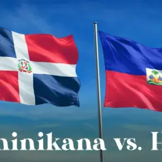 Flagi Dominikany i Haiti, państw sąsiadujących z Haiti, powiewają na tle błękitnego nieba.