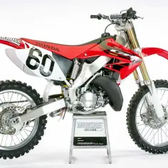 Czerwony motocykl Honda CR 125 z numerem 60. Zastanawiasz się, honda cr 125 ile koni mocy oferuje?