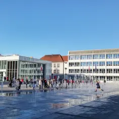 Dzieci biegają przez fontanny na placu w Koszalinie, gdzie leży to piękne miasto.
