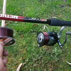 Wybieram żyłkę do method feeder. Na trawie leży wędka, kołowrotek i szpulka z żyłką.