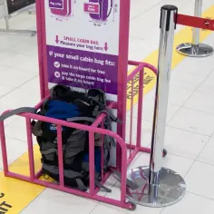 W bagażu podręcznym można przewozić kubek, jeśli mieści się w wyznaczonych wymiarach. Plecaki w różowym koszu czekają na pomiar.