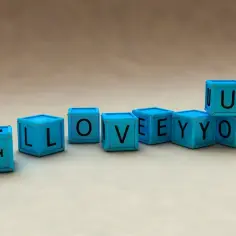 Niebieskie klocki układają się w napis "I LOVEYOO". Tak się pisze "I love you" w prosty sposób.
