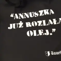 Czarna torba z napisem "ANNUSZKA JUŻ ROZLAŁA OLEJ." i logo Szarlatan.