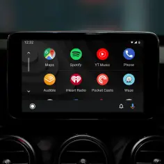 Ekran samochodu z ikonami aplikacji: Mapy, Spotify, YT Music, Telefon, Audible, iHeart Radio, Pocket Casts, Waze. To właśnie android auto co to za system.