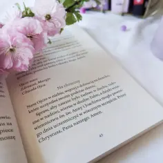 Otwarta księga z tekstem modlitwy do św. Anny i Joachima, ozdobiona gałązką kwitnącej wiśni.