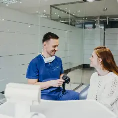 Dentysta w gabinecie rozmawia z pacjentką, która cierpi na ból zęba. Może zaproponuje jej ketonal.