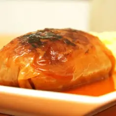 Pyszne, rumiane gołąbki w sosie, właśnie wyjęte z piekarnika, obok porcja purée.