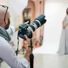 Fotograf w studio przygotowuje się do sesji. Zastanawiasz się, ile kosztuje fotograf na 18. urodziny?