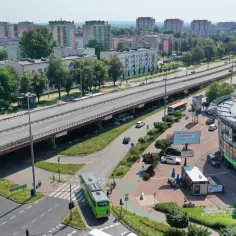 Widok z lotu ptaka na ruchliwą drogę, most i budynki mieszkalne. To może być najdłuższa ulica w Polsce, tętniąca życiem.