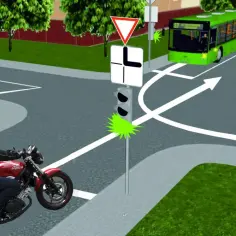 Motocyklista zbliża się do skrzyżowania dróg. Zielone światło dla niego, ale autobus jedzie z naprzeciwka.