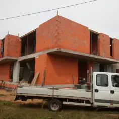 Budowa domu z cegły ceramicznej, gotowego do tynkowania. Zastanawiasz się, ile trwa tynkowanie domu? To zależy od wielu czynników, ale ten etap budowy jest kluczowy.