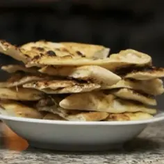 Stos wyrośniętego ciasta na pizzę w misce. Idealne, gdy zastanawiasz się, co zrobić z wyrośniętym ciastem na pizzę.