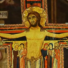 Starożytny krzyż św. Franciszka z malowanymi postaciami Jezusa, Maryi, Jana i aniołów.