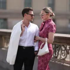Elegancka para, inspiracja: jak ubrać się na poprawiny - stylizacje. Ona w sukience w róże, on w białej koszuli i marynarce.