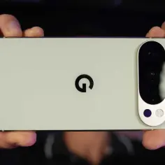 Gros plan sur le dos d'un smartphone Google Pixel vert pâle, tenu par deux mains.