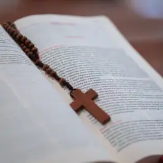 Różaniec na otwartej księdze, symbol wiary i refleksji nad grzechami przeciwko duchowi świętemu.