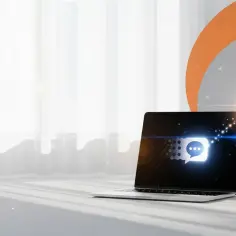 Laptop z ikoną czatu na ekranie i unoszącą się nad nim ikoną powiadomienia.