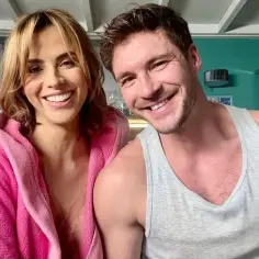 Michalina Sosna i jej mąż uśmiechają się do zdjęcia. Ona w różowym szlafroku, on w szarym podkoszulku.